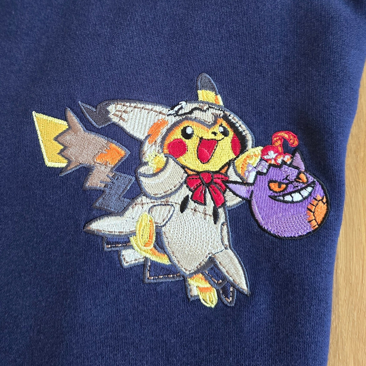 Détail de la broderie Pikachu en costume de Mimiqui avec son sac de bonbons